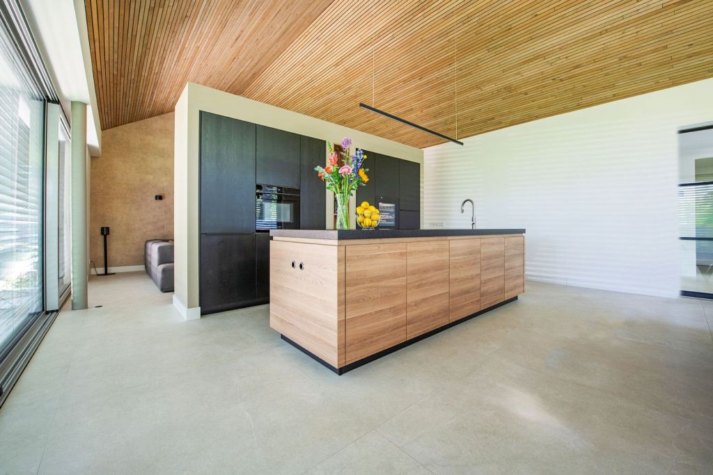 Moderne keuken met zwart stenen kookeiland, houten kasten